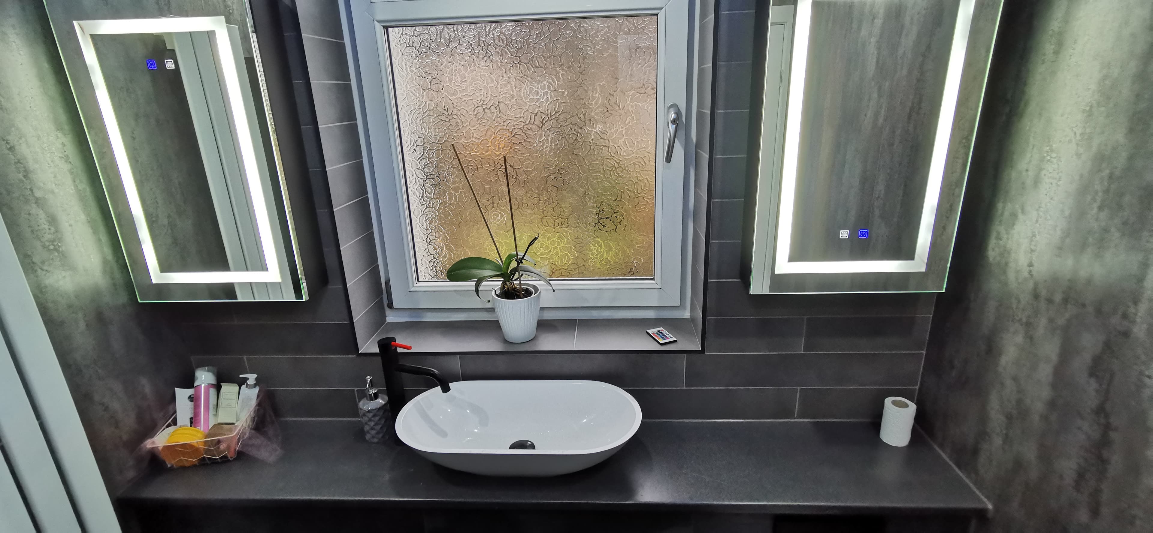 Curved glass shower enclosure with black frame and rainfall shower head