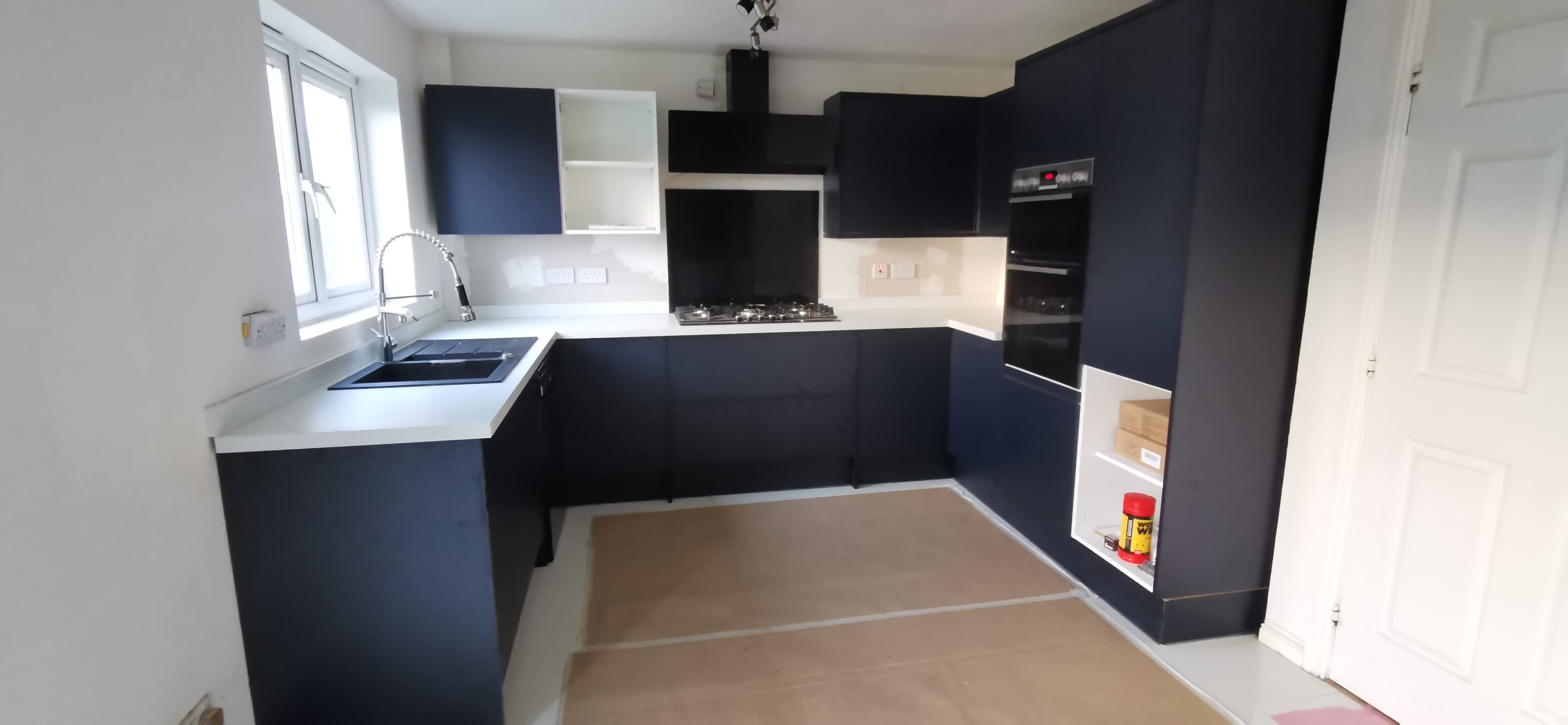Fitted kitchen with integrated extractor and tiled splashback